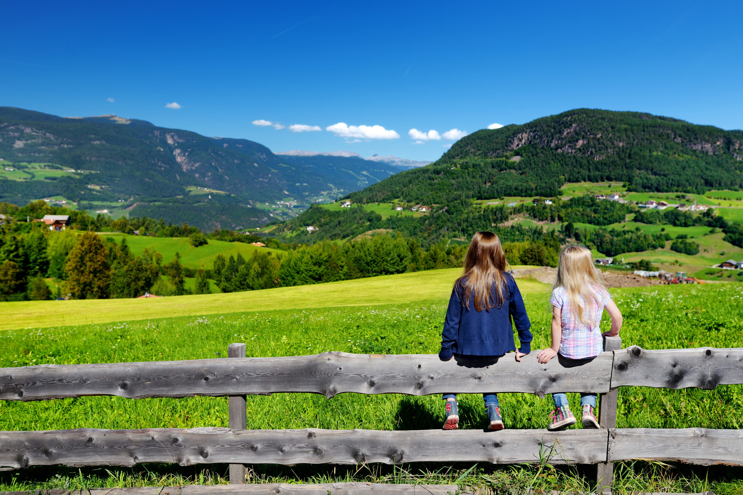 Two adorables little sisters admiring beautiful landscape of Dolomites mountain range, South Tyrol, Italy